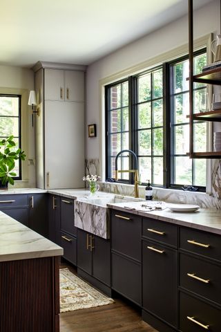 A kitchen with marble countertops and black slim style shaker cabinets