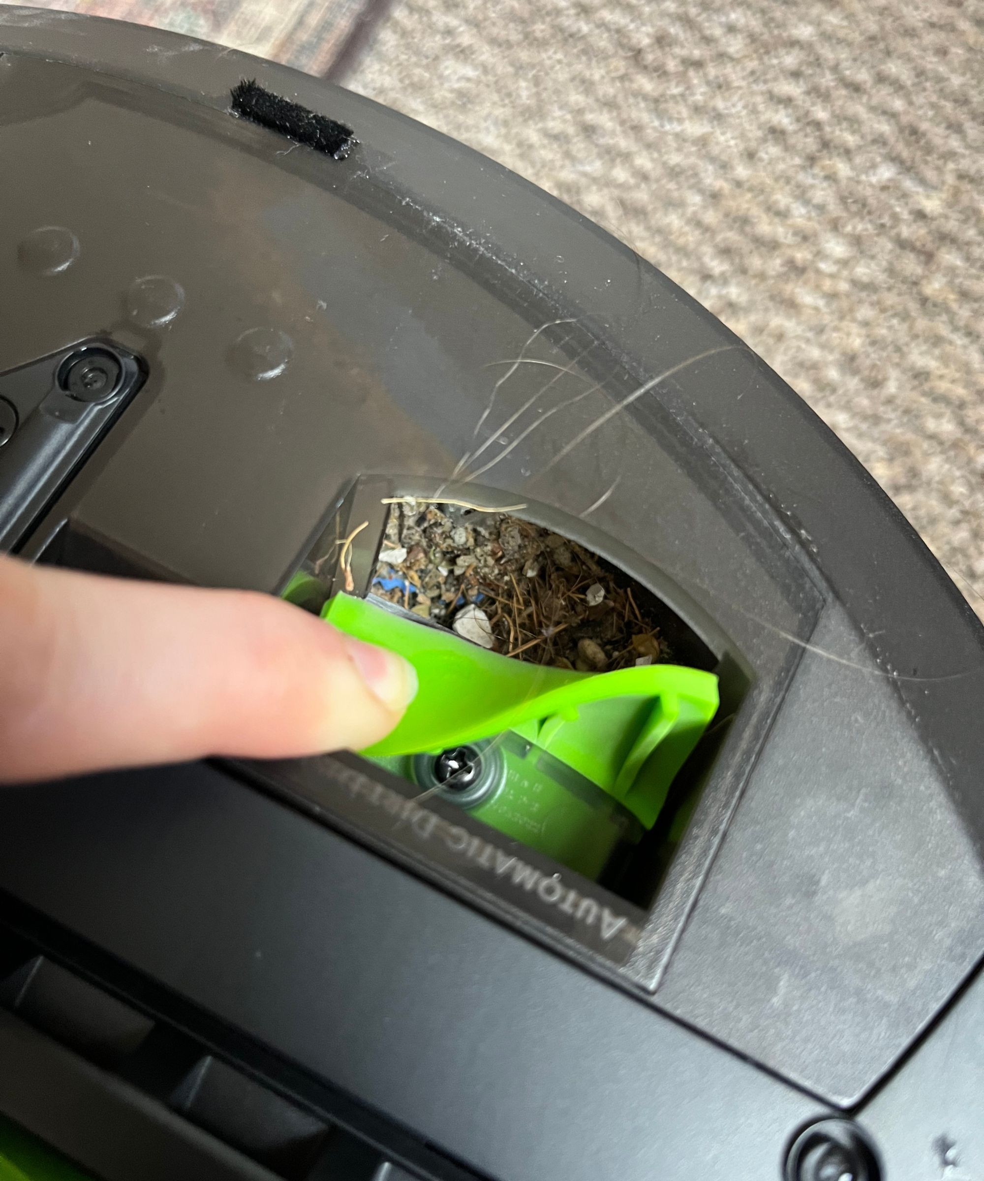 Pulling back the dirt flap after emptying to reveal dirt still stuck in the system