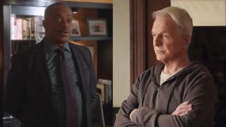 Rocky Carroll stands speaking in his office, and Mark Harmon looks pensive while standing in a well lit room on NCIS, pictured side by side.