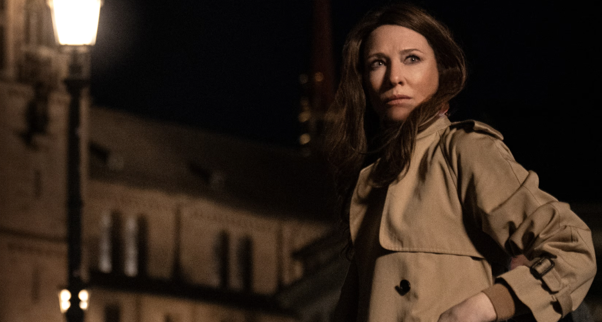 cate blanchett wearing a trench coat walking through london at night in the movie black bag