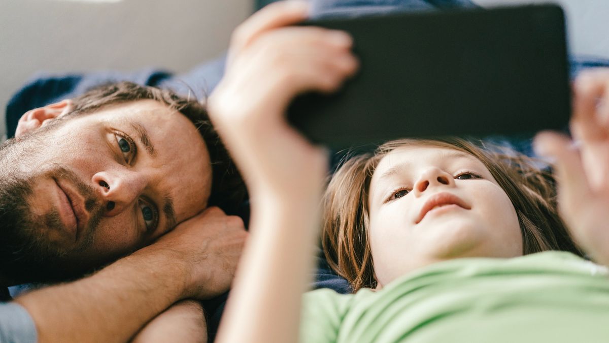 Father and son looking at smartphone together at home