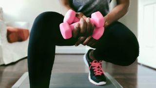 Woman exercising with weights at home