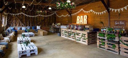 Party Barn decorated for social event, with bunting, string lights and illuminated bar sign