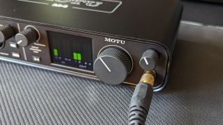 A pair of headphones plugged into the Motu M4