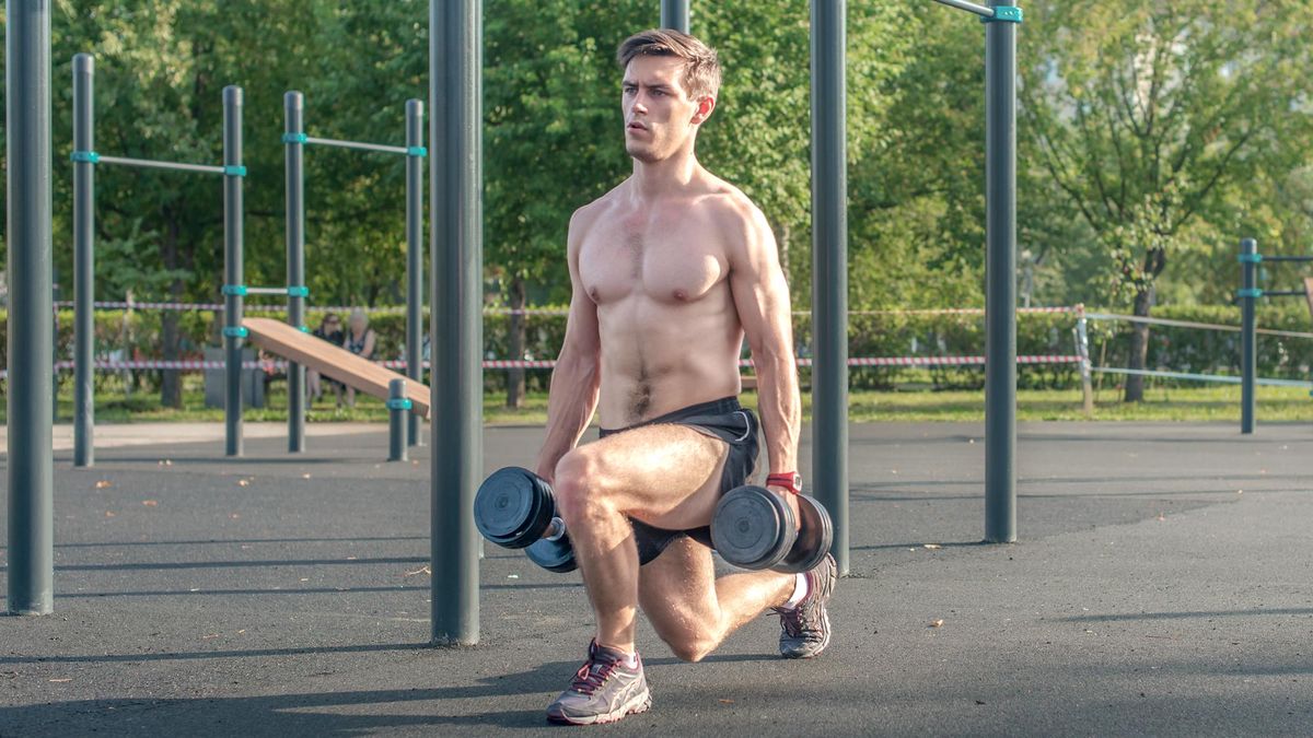 Man doing a forward lunge with dumbbells outside