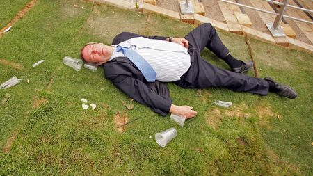 ASCOT, UNITED KINGDOM - JUNE 20:A man lies on the ground as race-goers walk past him on the first day of Royal Ascot, at the Ascot Racecourse on June 20, 2006 in Ascot, England.The event has 