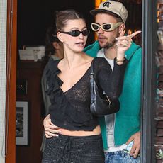 Hailey Bieber wears a crochet knit top and skirt, carries black Gucci Jackie Slim bag