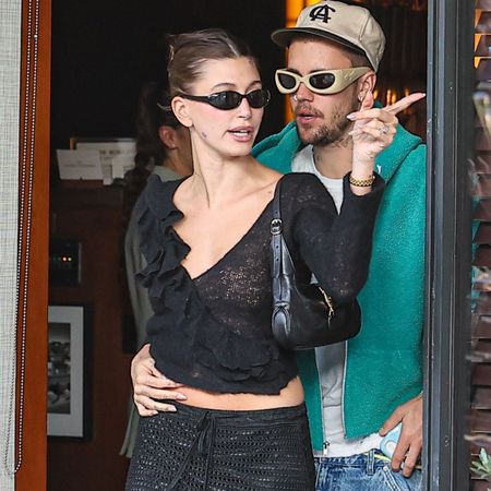 Hailey Bieber wears a crochet knit top and skirt, carries black Gucci Jackie Slim bag