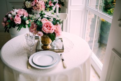 Simon Lycett flower arrangement with roses on a breakfast table