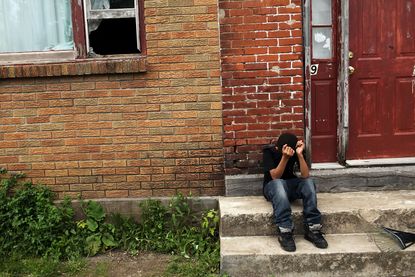 A child sits on a stoop in a working class section of Utica, New York.