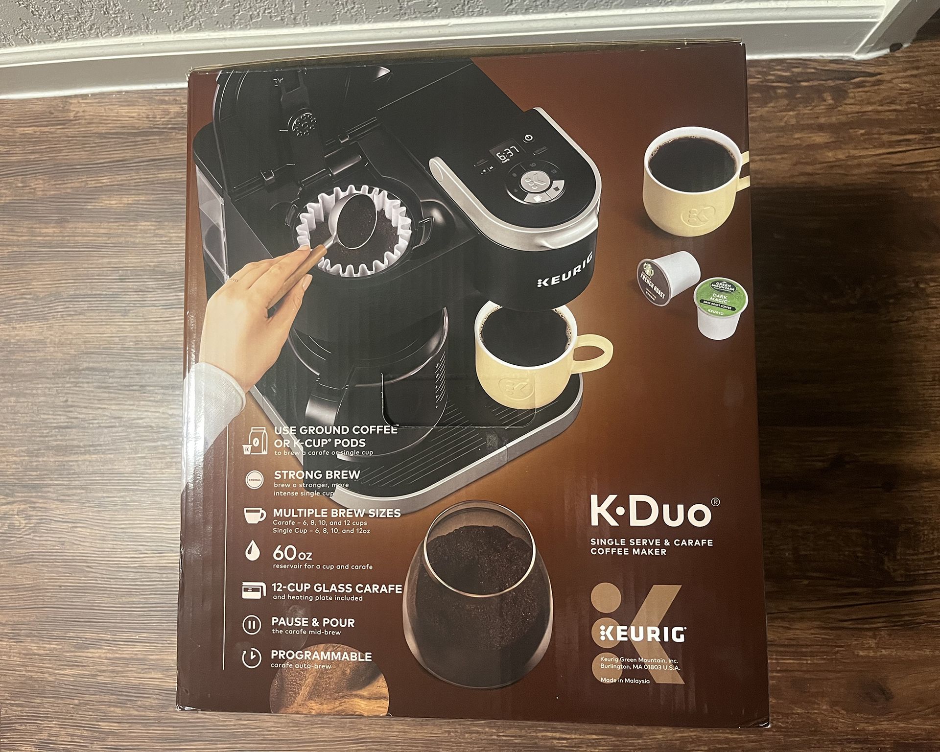 Pembuat kopi sekali pakai Keurig K-Duo dengan teko di lantai laminasi keras
