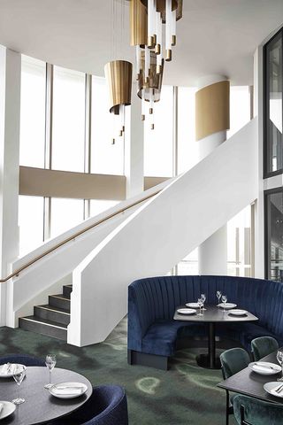 A staircase that curves up to a private dining room and bar