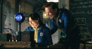 Two people in a vault at a desk smiling as they look at something