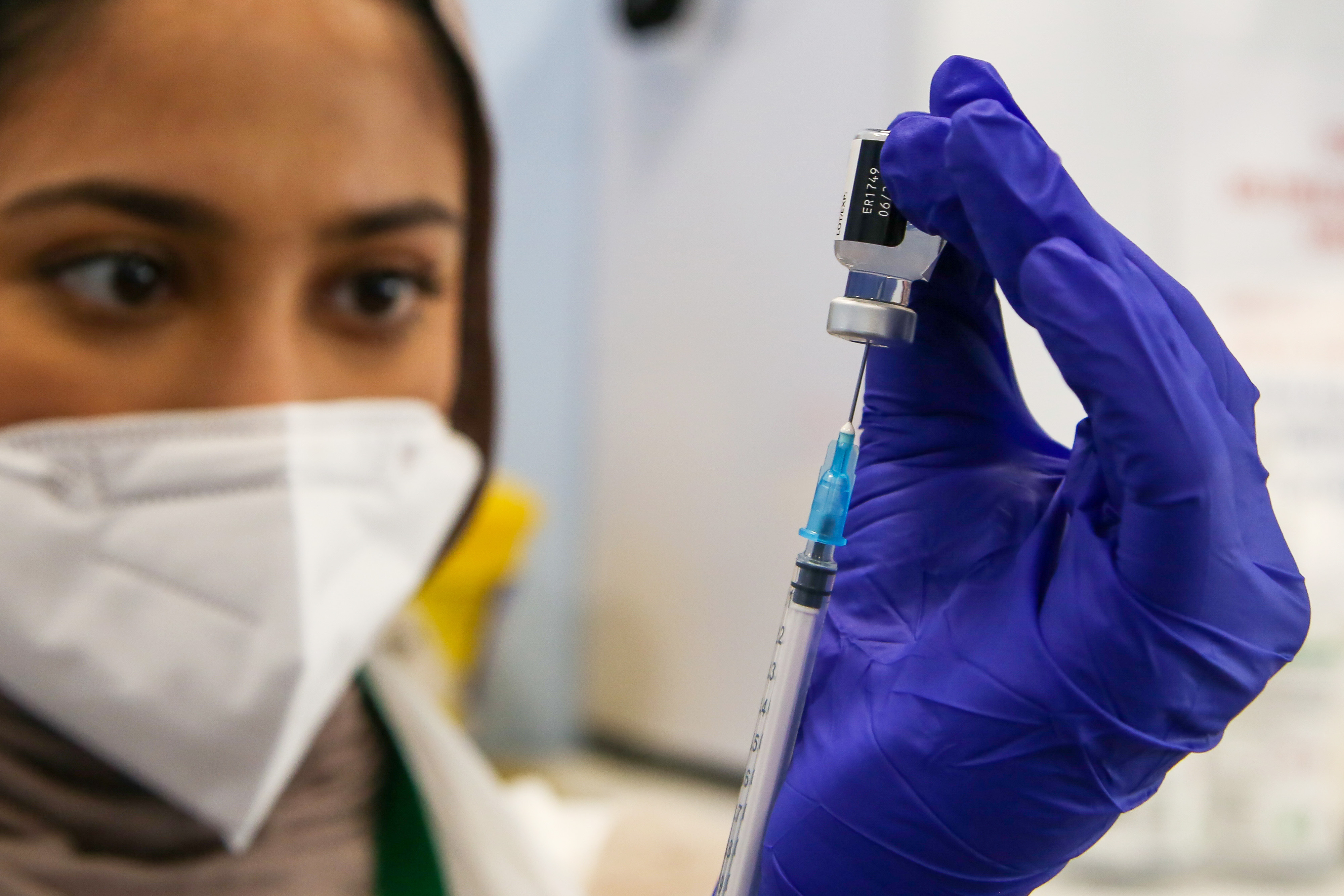 Woman preparing to administer the Pfizer vaccine
