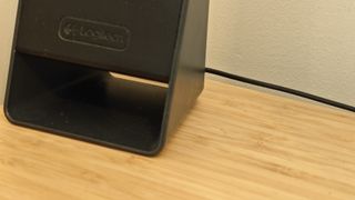 Black Logitech Z213 speakers sitting on a wooden desk