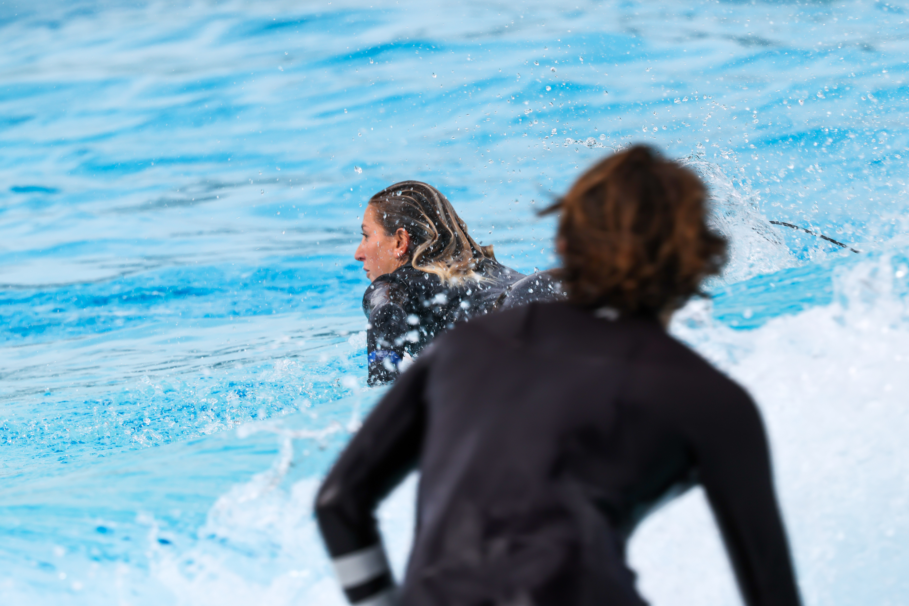 Dos surfistas en el agua en el parque de olas.