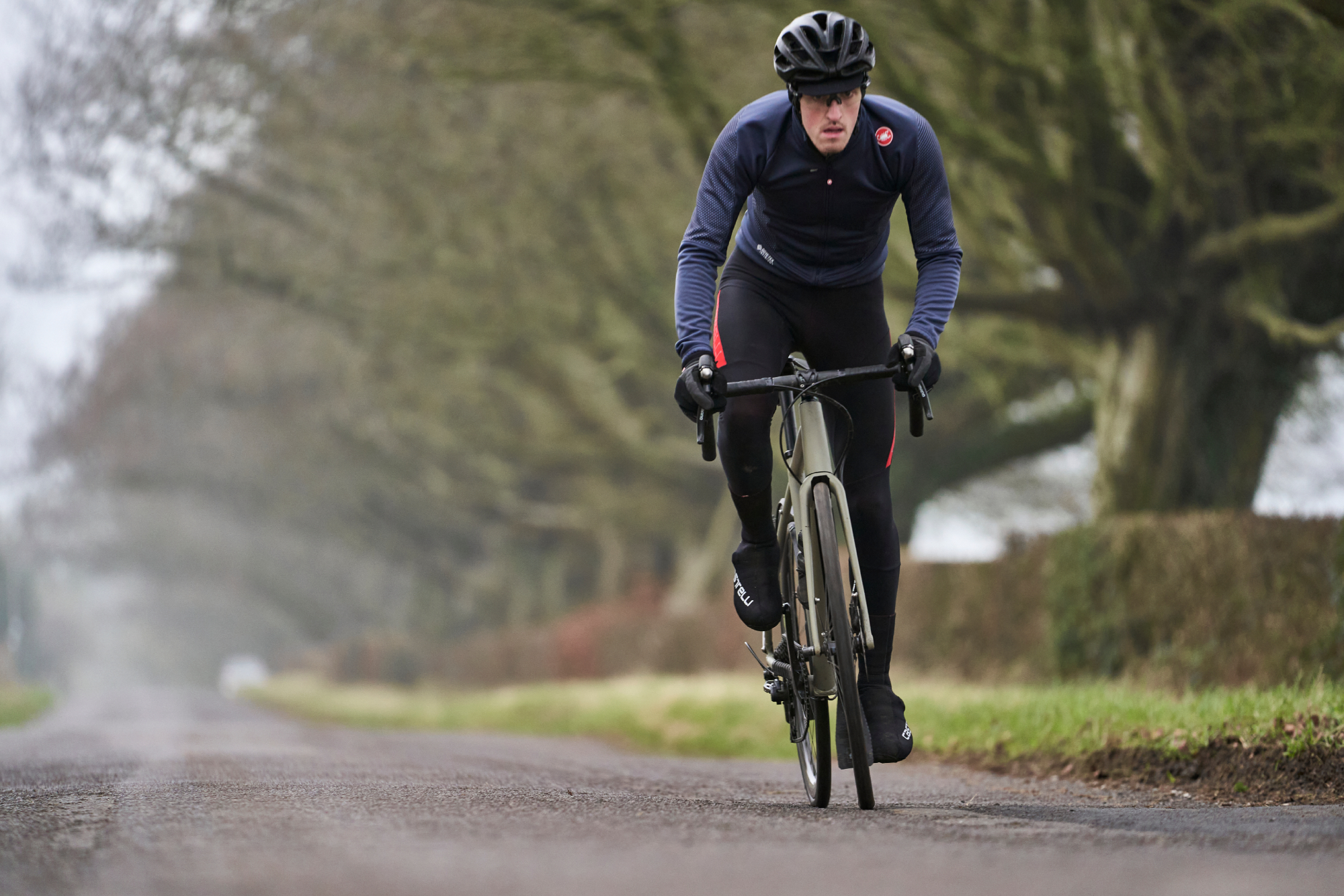 Image shows a person cycling during the winter