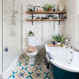 Bathroom with patterned floor tiles and salvaged scaffolding shelving with bath tub, shower and toilet