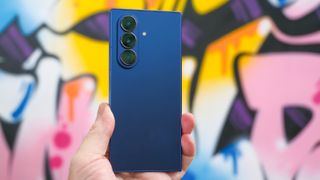 Samsung Galaxy Z Fold 7 in blue closed from the back with graffiti on the wall behind