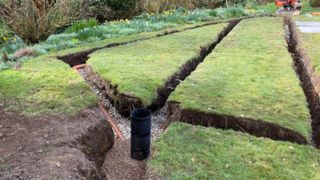 A drainage field with trenching dug out on a lawn