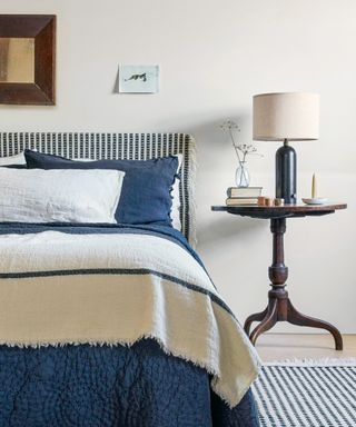 A crisp blue and white bedroom scheme with cream walls and faded navy bed linen.