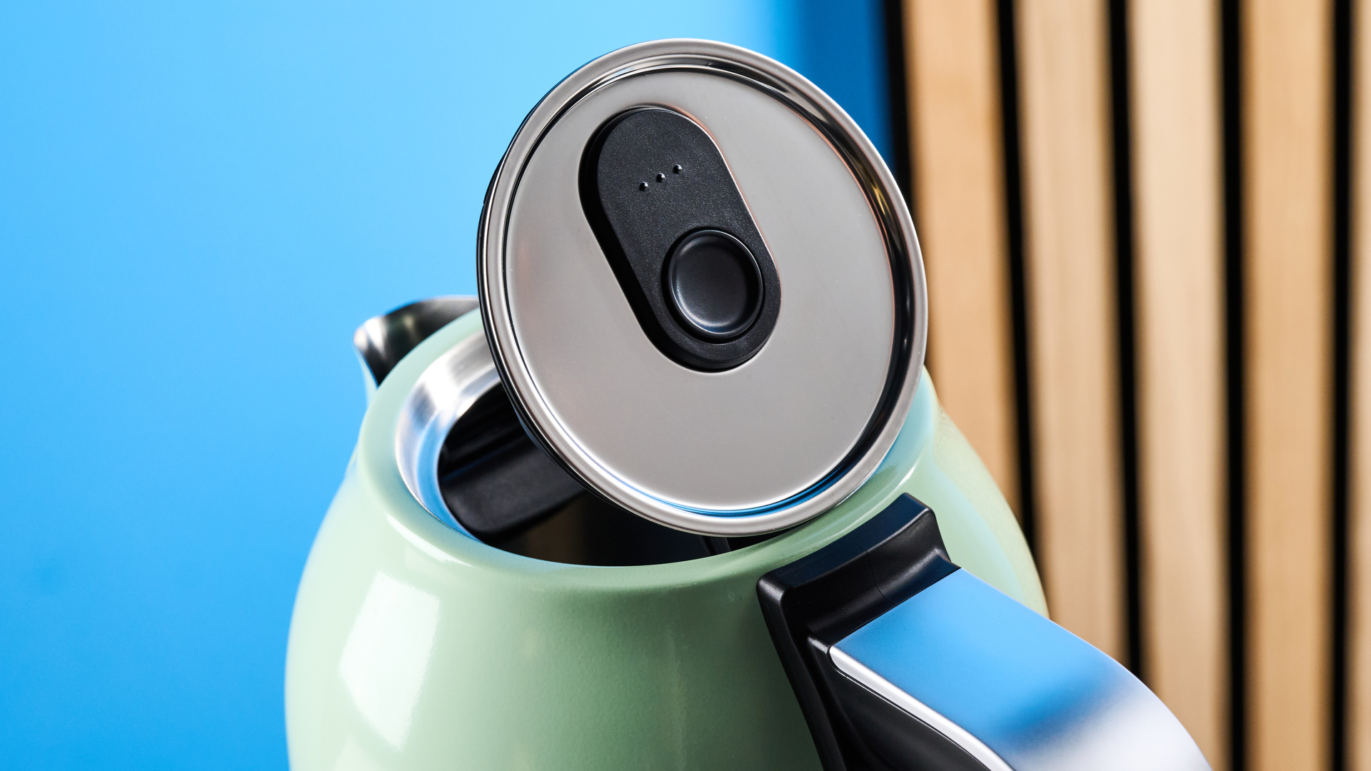 the kitchenaid 1.7L kettle in pistachio photographed on a white marble counter with a blue background