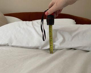 Coop Adjustable pillow with case on, measuring height on bed