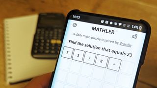 A phone displaying the web game Mathler with a calculator in the background