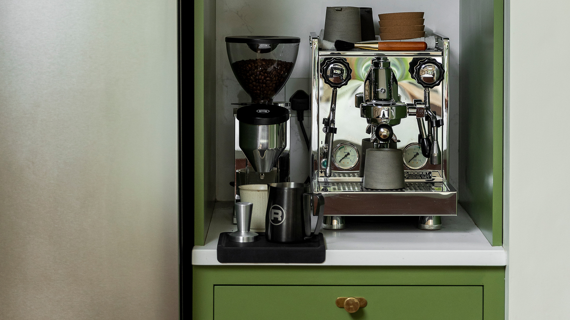 Close up of a coffee station in a olive green kitchen