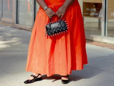 chichi wears red dress and spiked hand bag and kitten block heel slingbacks