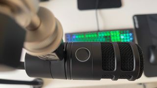 The Audio-Technica AT2040USB microphone on a mic stand in front of a monitor