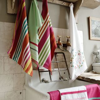 room with tiled walls and printed towels