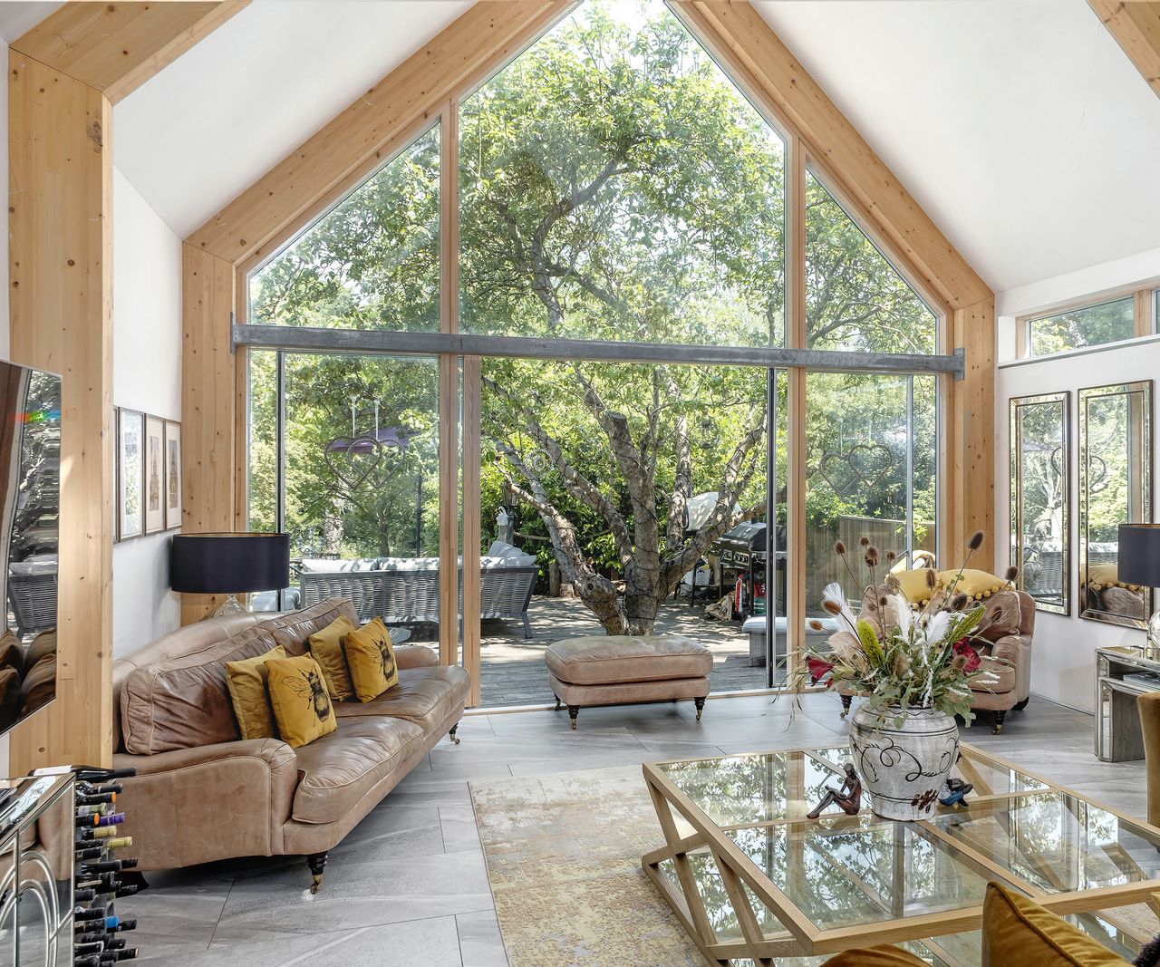 An open plan living room with large architectural glazing with sliding glass doors.