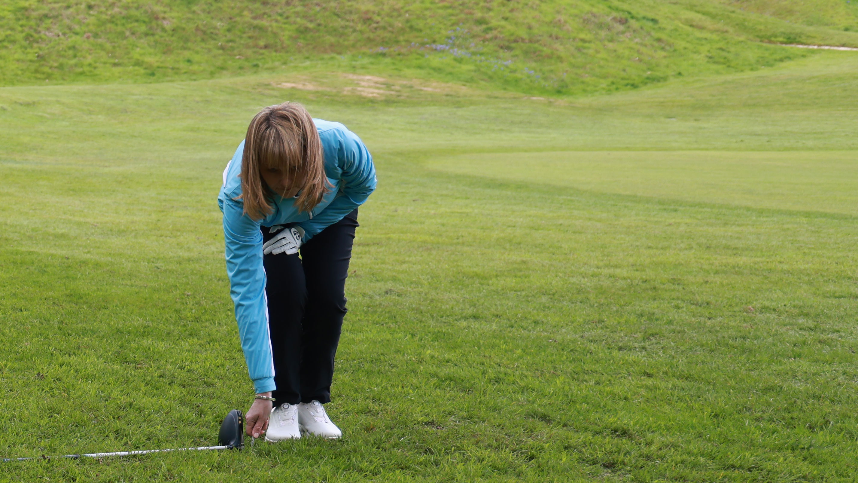 A golfer measuring two club-lengths