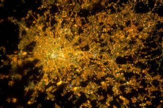 The city of Milan, Italy appears as a cluster of lights in this photograph, with brilliant white lights indicating the historic city center where the Duomo di Milano (Milan Cathedral) stands. The Expedition 26 crew aboard the International Space Station t