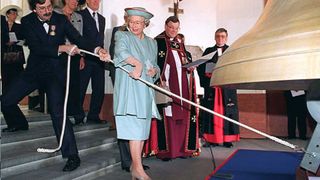Queen Elizabeth II (C), with the aid of Timothy Hurd (L), tolls the Bourdon Peace Bell at the National War Memorial in Wellington 05 November. The Queen is on the fifth day of her 10-day New Zealand tour.