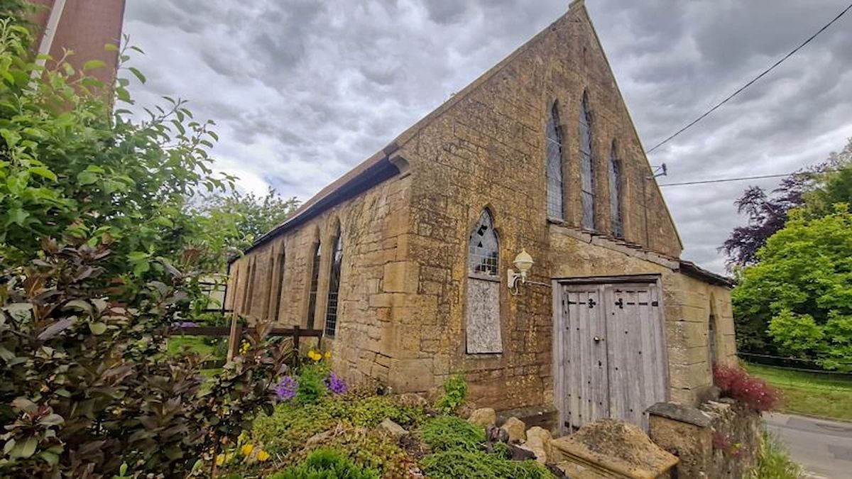 A chapel with wooden doors and a small garden