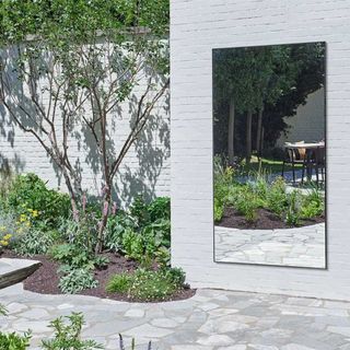 quiet luxury garden with large contemporary outdoor mirror