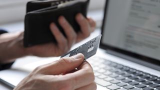 Hand holding a credit card ready to pay for an online purchase