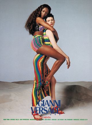 A 1993 Versace campaign by Richard Avedon featuring a standing Kristen McMenamy who has Naomi Campbell on her back. They are both wearing colourful outfits