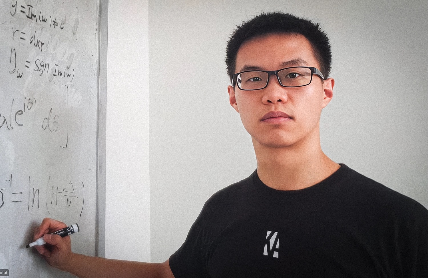 A photo of Zhiyuan Wang writing on a whiteboard