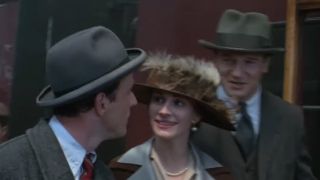 Julie Roberts walking with two other people, wearing a hat, in Michael Collins