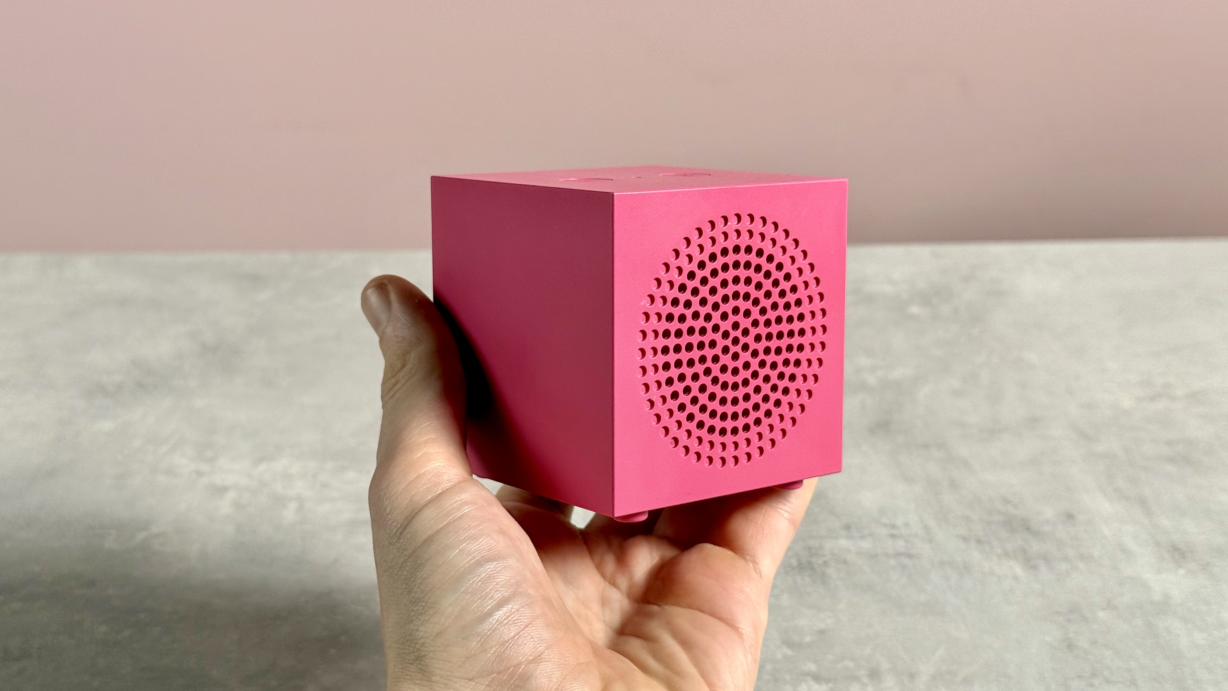 The Ikea Kallsup in Hot Pink help in a man's hand.