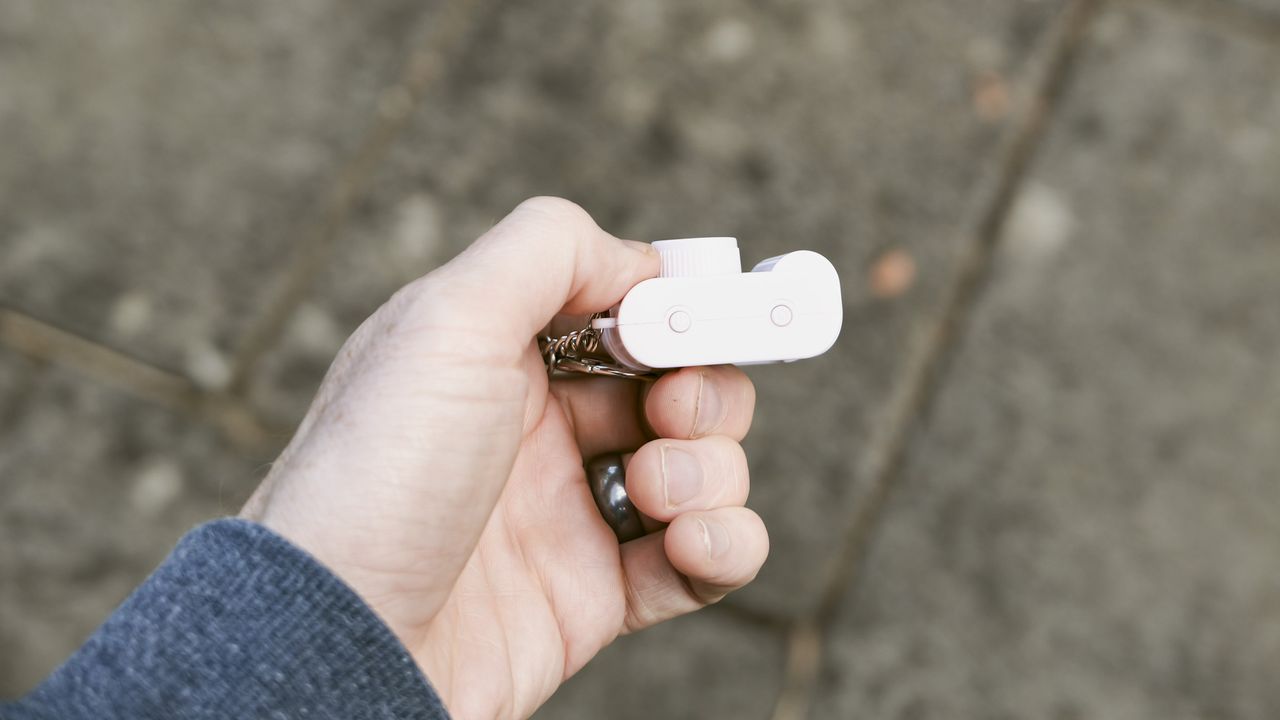 Miniature pink keychain camera, the 'Photo Creator Mini Digital Camera series 3', in user's hand, its topside