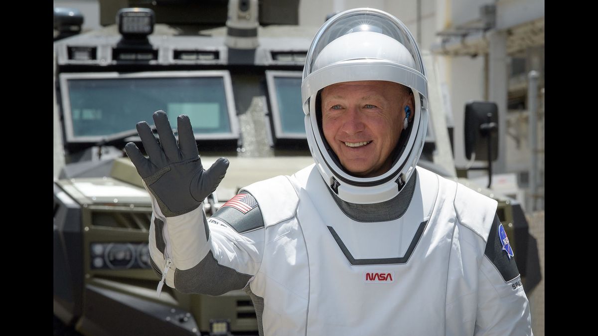 NASA astronaut Doug Hurley waves as he and Bob Behnken depart the Neil A. Armstrong Operations and Checkout Building for Launch Complex 39A to board the SpaceX Crew Dragon spacecraft for a second time, on May 30, 2020.