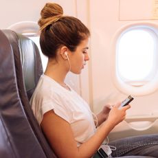 Woman on her phone on a plane