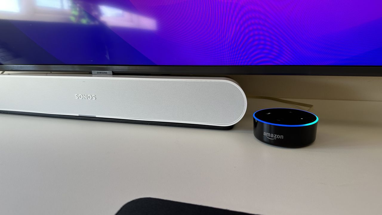 A white Sonos Ray under a TV and next to an Amazon Echo Dot