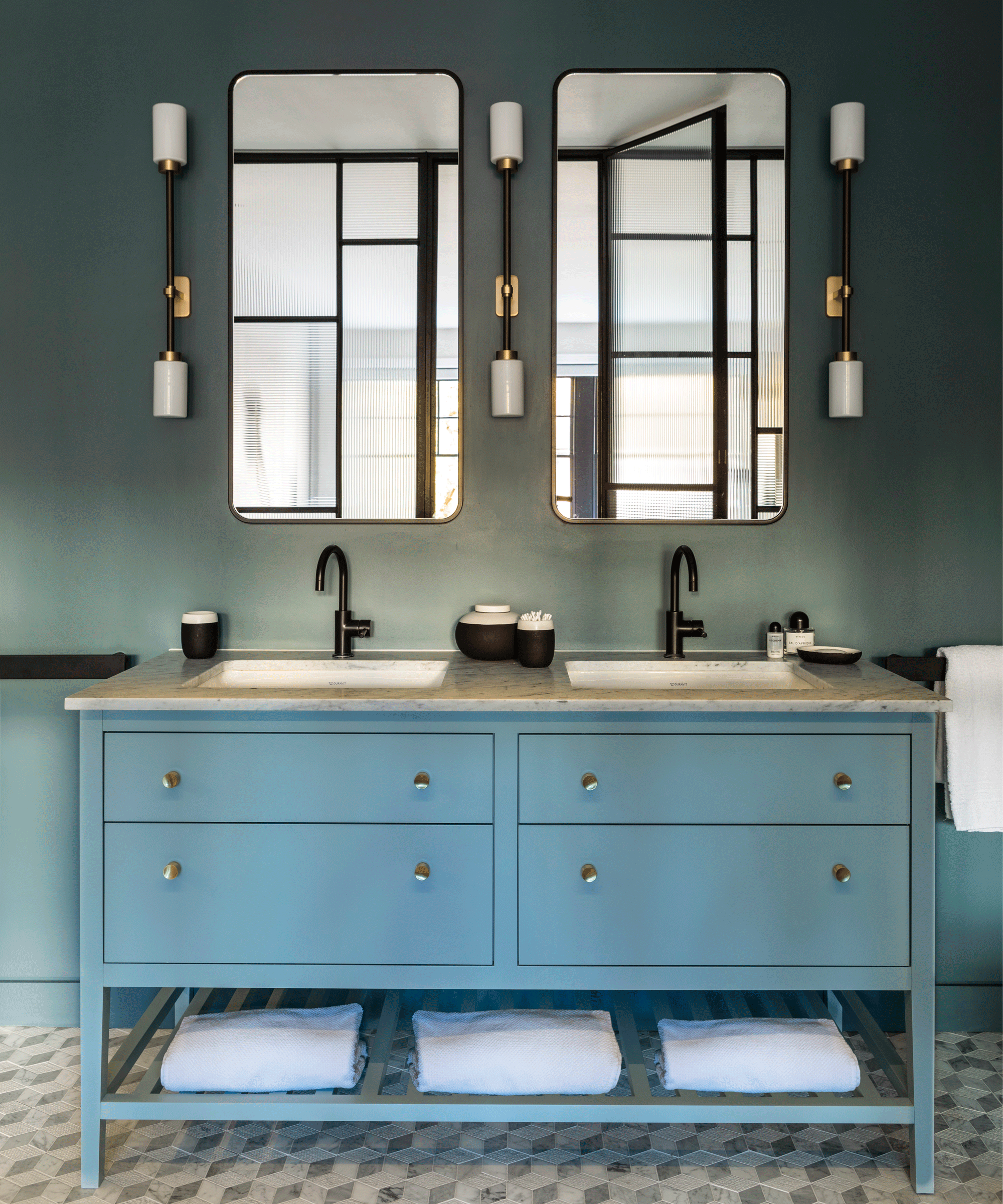 An example of bathroom vanity ideas showing a blue double bathroom vanity with towel storage below and matching mirrors and wall lights above