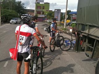 Racers wait with their bikes to be loaded into the truck