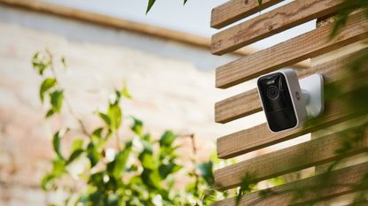 Yale Smart Outdoor Camera review: camera mounted up on a wooden wall